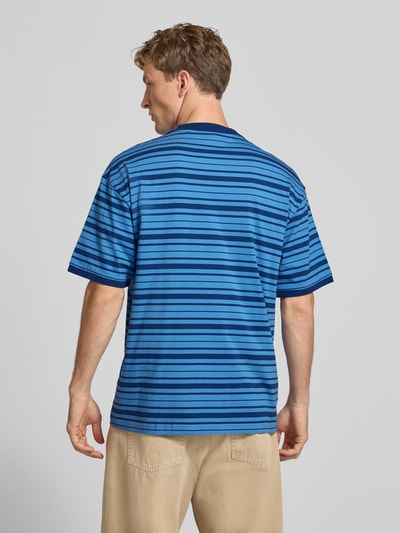 Männermodel trägt Regular Fit T-Shirt aus reiner Baumwolle Modell 'Nistripe' von HUGO Blue, blaue Streifen, Ganzkörperansicht Rückansicht.