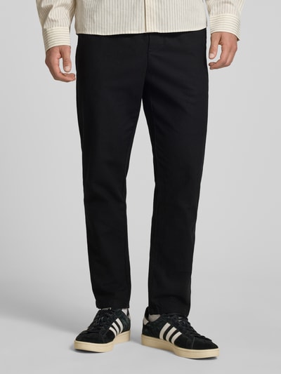 Männermodel trägt Tapered Leinenhose aus Baumwoll-Leinen-Mix Modell 'LINUS' von Only & Sons in schwarzer Melange-Optik, Ganzkörperansicht von vorne.