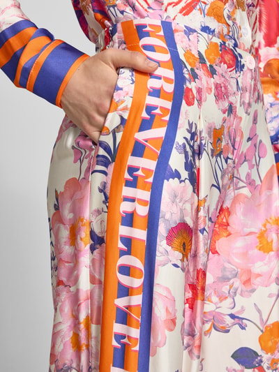 Frauenmodel trägt Wide Leg Hose aus Viskose Modell 'wild Flower' von miss goodlife, florales Muster, bunte Farben, Textprint, Nahaufnahme Oberkörper.