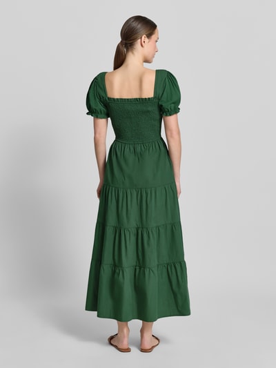 Modelka nosi długa sukienka 'Maxikleid mit Smok-Details und Karree-Ausschnitt' od Apricot, zielona bawełna, taliowany fason, rękawy z falbanami; długość tyłu w rozmiarze S: 116 cm, szerokość w rozmiarze S: 32 cm, długość rękawów w rozmiarze S: 21 cm; widok całej sylwetki z tyłu.