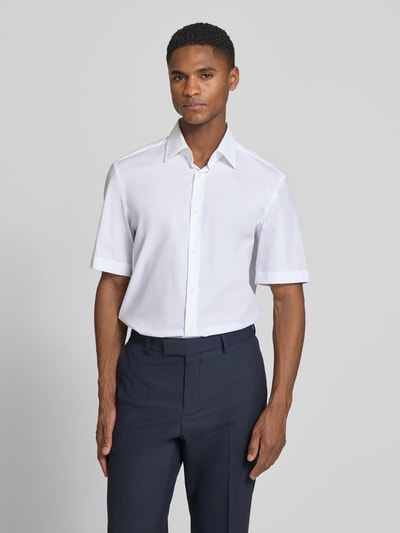 Männermodel trägt Regular Fit Businesshemd aus Baumwoll-Mix Modell 'H-JOE-K-SH-C1-262' von BOSS, Optik: Unifarben, Ganzkörperansicht von vorne.