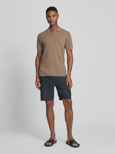 Męskimodel nosi Slim Fit Poloshirt model 'Triton' od Drykorn z bawełny, kołnierzyk polo, fakturowany wzór, krótki rękaw, długość tyłu 67 cm, krój slim fit, widok całej sylwetki z przodu.