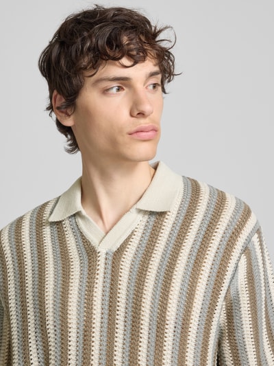 Männermodel trägt Regular Fit Poloshirt aus Baumwoll-Mix Modell 'THUE' von Only & Sons mit gestreiftem Allover-Lochstrickmuster in Beige, Braun und Grau, Polokragen, V-Ausschnitt, kurzarm, Rippenabschlüsse, Nahaufnahme Oberkörper.