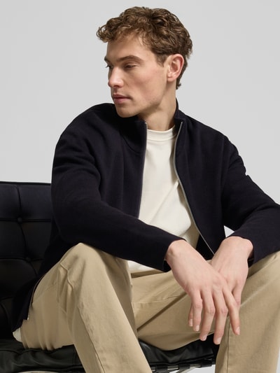 Männermodel trägt Relaxed Fit Strickjacke aus Viskose-Mix Modell 'TELLER' von SELECTED HOMME, unifarben, Feinstrick, Nahaufnahme Oberkörper.