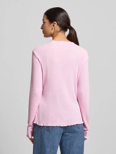 Modelka kobieta ma na sobie Slim Fit Langarmshirt mit Viskose-Anteil od s.Oliver RED LABEL w kolorze jasnoróżowym, żebrowana faktura, krój slim fit, wysoki dekolt, długie rękawy, wykończenia typu frill, label stitching; widok całej sylwetki od tyłu.