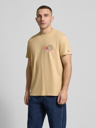 Männermodel trägt Regular Fit T-Shirt aus reiner Baumwolle von Tommy Jeans, Optik: Unifarben, Label-Print, Rundhals, Kurzarm, Jersey; Ganzkörperansicht von vorne.