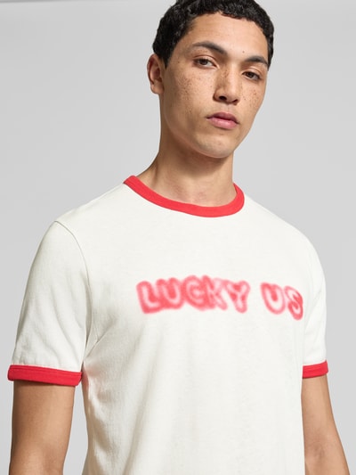 Männermodel trägt Regular Fit T-Shirt aus reiner Baumwolle von Kenzo in Weiß mit rotem Statement-Print, Rundhalsausschnitt, Kurzarm, Nahaufnahme Oberkörper. Rückenlänge bei Größe M 64 cm.