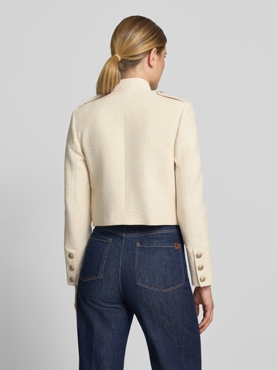 Frauenmodel trägt Blazer mit Zierknöpfen Modell 'CHARLIE' von MANGO in Creme, gerader Schnitt, strukturierte Oberfläche, Ganzkörperansicht Rückansicht. Baumwoll-Mix mit Viskose-Anteil, Stehkragen, klassische Jeans.