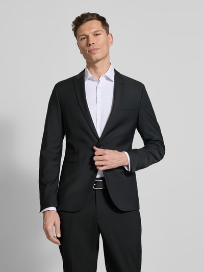 Männermodel trägt schwarzes Regular Fit Sakko mit Woll-Anteil Modell 'Irving' von Drykorn, glatter Stoff, Reverskragen, Nahaufnahme Oberkörper.