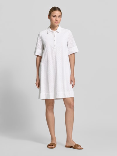 Frauenmodel trägt Knielanges Hemdblusenkleid mit Lochstickerei von Christian Berg Woman aus Reine Baumwolle, Weiß, Gerader-Schnitt, Knopfleiste, Hemdblusenkragen, Ganzkörperansicht von vorne.