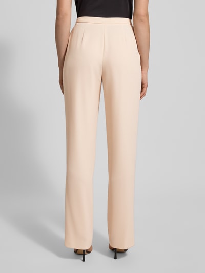 Frauenmodel trägt Stoffhose mit Bundfalten von Emporio Armani in Beige, lockerer Schnitt, Bundfalten, Ganzkörperansicht Rückansicht.