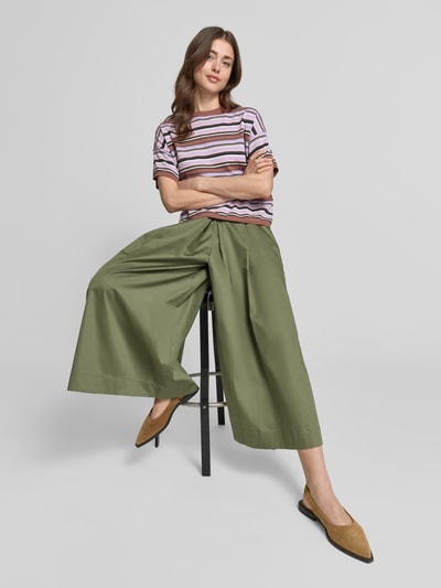 Kobieta prezentuje spodnie materiałowe Wide Fit Stoffhose mit Bundfalten von Christian Berg Woman, zielony, bawełna, skrócony krój, zakładki w pasie, elastyczny pas, szerokość w rozmiarze 36: 36 cm, długość wewnętrzna nogawki w rozmiarze 36: 61 cm, ujęcie: całe ciało z przodu.