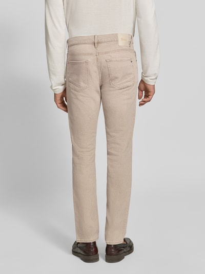 Männermodel trägt helle, beige Slim Fit Jeans aus Baumwoll-Mix Modell 'Chuck' von Brax, Herren Slim Fit Jeans, Ganzkörperansicht Rückansicht.