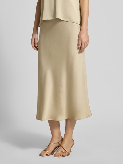 Frauenmodel trägt Midirock mit elastischem Bund von Drykorn, beigefarbener Satin, leichte A-Linie, Midilänge, Nahaufnahme Unterkörper.