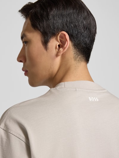 Männermodel trägt Regular Fit T-Shirt aus Baumwoll-Mix Modell 'TEETIM' von BOSS Orange, Optik: Unifarben, Label-Print, Nahaufnahme Rückansicht.