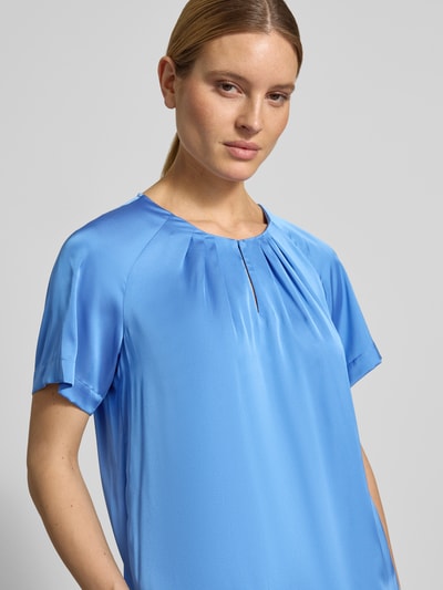 Frauenmodel trägt Blusenshirt aus Satin mit Rundhalsausschnitt von Comma in Blau, mit Drapierungen, Regular-Fit, Nahaufnahme Oberkörper. Rückenlänge bei Größe 36: 60 cm, Ärmellänge: 33 cm.