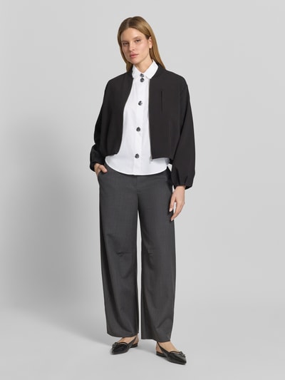 Kobieta nosi Regular Fit Bluse aus Baumwolle mit Ballonärmeln od ARMANI EXCHANGE, biała bluzka z bawełny, kołnierzyk koszulowy, listwa guzikowa, bufiaste rękawy, długość tyłu 57 cm, długość rękawów 57 cm, krótka kurtka, szerokie szare spodnie, neutralne kolory, gładka faktura, Ganzkörperansicht von vorne.