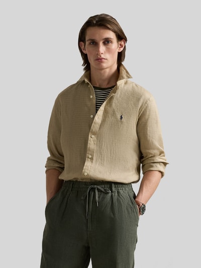 Męski model nosi Slim Fit Freizeithemd aus reinem Leinen von Polo Ralph Lauren w jednolitym beżu, krój slim fit, len, całe ciało z przodu.