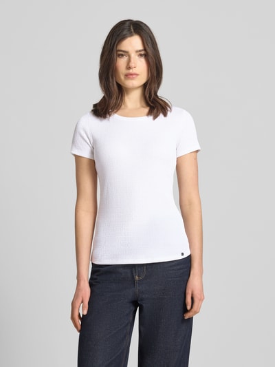 Vrouwenmodel draagt T-shirt met Label-Detail van Marc Cain in wit, elastische materiaalmix, nauwsluitend model, u-hals, ruglengte maat 36: 55 cm, labeldetail, geheel in beeld voorkant