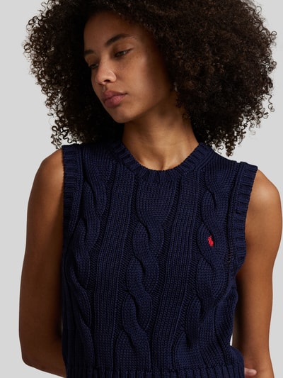 Kobiece model prezentuje Bezrękawnik z wyhaftowanym logo Polo Ralph Lauren z bawełny, krój regular fit, prążkowane wykończenia, okrągły dekolt, długość tyłu w rozmiarze S: 48 cm, zbliżenie na górną część ciała.