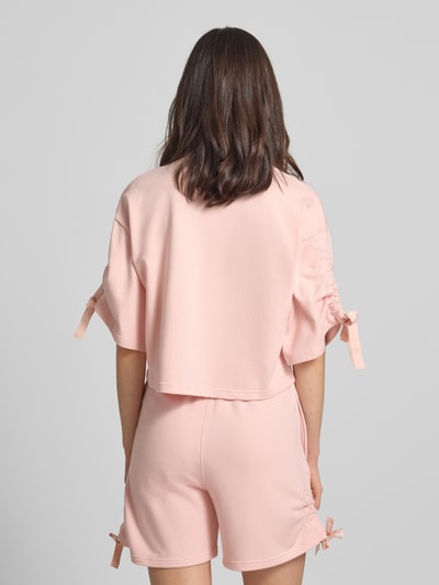 Frauenmodel trägt Boxy Fit Pyjama-Oberteil mit Baumwoll-Anteil von HUGO in Optik: Unifarben, Sweat-Material, Cropped-Länge, Rückansicht.