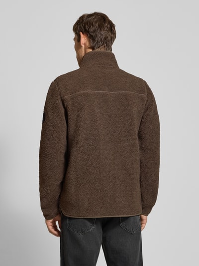 Männermodel trägt Regular Fit Jacke mit Stehkragen Modell 'Peter' von Didriksons, braune Struktur, Rückenansicht, Kontext: Brusttasche, Reißverschluss, Länge 74 cm, Schulterbreite 40 cm, Brustweite 53 cm, Ärmellänge 72 cm. Ganzkörperansicht Rückansicht
