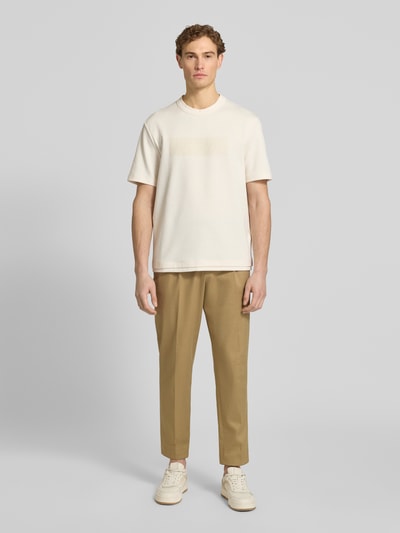 Männermodel trägt T-Shirt mit Logo und Rundhalsausschnitt von ARMANI EXCHANGE in Regular-Fit aus reiner Baumwolle, Ganzkörperansicht von vorne. Rückenlänge bei Größe M: 71 cm.