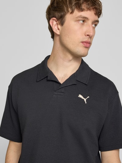 Männermodel trägt Regular Fit T-Shirt mit Logo-Stitching von PUMA PERFORMANCE im Baumwoll-Mix mit Stretch-Anteil, Strukturmuster, Nahaufnahme Oberkörper.