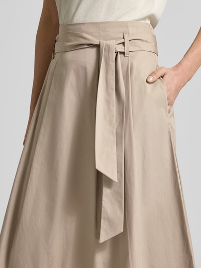 Frauenmodel trägt Regular Fit Midirock in Falten-Optik von Christian Berg Woman aus Reine Baumwolle, beige, mit Stoffband, Nahaufnahme Oberkörper.