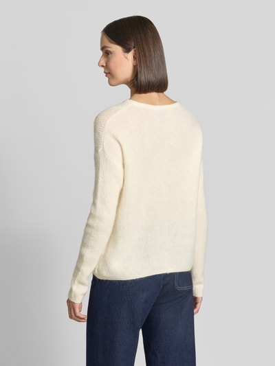 Frauenmodel trägt Regular Fit Strickjacke aus Woll-Alpaka-Mix Modell 'Almine' von MOS MOSH, cremefarben, weiche Textur, Ganzkörperansicht Rückansicht. Damen Strickjacke, Langarm, Knopfleiste und Label-Emblem, Rückenlänge und Ärmellänge bei Größe S.
