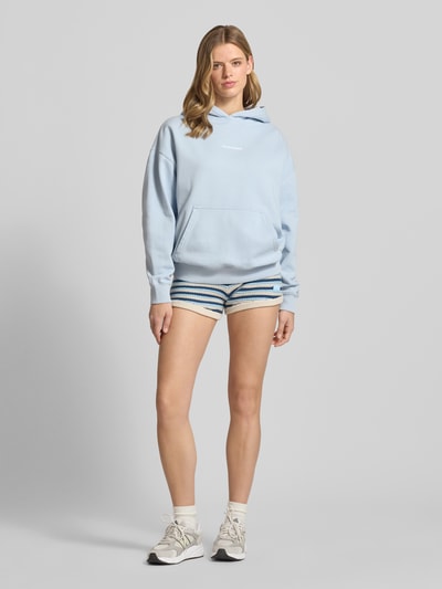 Frauenmodel trägt Shorts in Strick-Optik von Pegador aus reiner Baumwolle mit Label-Patch, körpernahe Passform, Ganzkörperansicht von vorne.