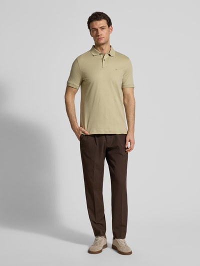 Männermodel trägt Regular Fit Poloshirt mit Logo-Stitching von Fynch-Hatton in Beige, reine Baumwolle, Polokragen, Ganzkörperansicht von vorne.