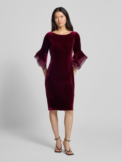 Frauenmodel trägt Abendkleid aus Samt mit Rundhalsausschnitt von Adrianna Papell in Dunkelrot, taillierte Passform, Material-Mix, Stretch-Anteil, rückseitiger Reißverschluss, glatte samtige Textur, Ganzkörperansicht von vorne.