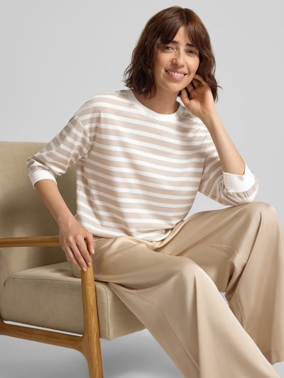 Kobiece model nosi Longsleeve mit Rundhalsausschnitt und 3/4-Arm od Marc Cain, Mieszanka materiałów z dodatkiem streczu, krój relaxed fit, wzór na całej powierzchni, efekt błyszczący, okrągły dekolt, rękaw o dł. 3/4, Długość tyłu w rozmiarze 36: 55 cm, jasne beże i biel, miękka tekstura, widok na cały przód sylwetki, zdjęcie górnej części ciała