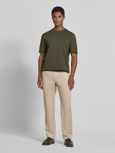 Männermodel trägt Regular Fit T-Shirt aus reiner Baumwolle Modell 'TORINO' von SELECTED HOMME, unifarbenes Olivgrün, Rundhals, kurzarm, gerippte Abschlüsse, Ganzkörperansicht von vorne.