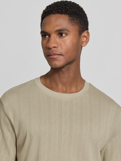 Männermodel trägt T-Shirt in Jaquard-Strick mit Rundhalsausschnitt von Lindbergh, neutrale Farbe, reine Baumwolle, Nahaufnahme Oberkörper.