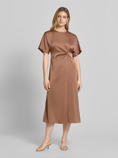 Vrouwenmodel draagt midi-jurk met knoopdetail model 'Dela' van JOOP!, satijn, recht model, ronde hals, volledig beeld frontaal.