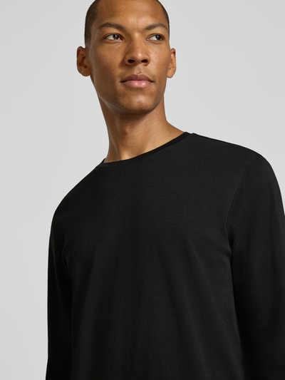Männermodel trägt Longsleeve aus reiner Baumwolle von Christian Berg Men in Schwarz, lockere Passform, Nahaufnahme Oberkörper.