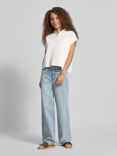 Kobiece model prezentuje Regular Fit Poloshirt aus reiner Baumwolle od Marc O'Polo Denim, efekt: jednolity kolor, krój regular fit, naszywka z logo, kołnierzyk polo, dekolt w serek, krótkie zapięcie na guziki, krótki rękaw, wykończenie materiału: pika, materiał: bawełna; ujęcie: całkowity widok z przodu.