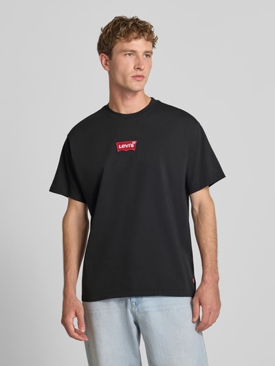 Męski model nosi Regular Fit T-Shirt aus reiner Baumwolle von Levi's®, czarny kolor, kontrastowe logo, gładka tekstura, Ganzkörperansicht von vorne