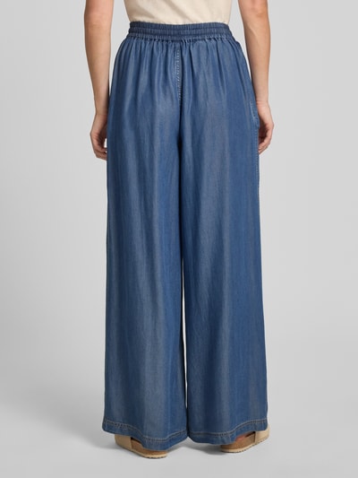 Frauenmodel trägt Wide Leg Weite Hose aus Lyocell Modell 'C_TANELLA' von BOSS Orange in Blau, lockere Passform, Damen Weite Hose, Ganzkörperansicht Rückansicht.