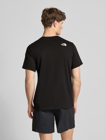 Männermodel trägt schwarzes T-Shirt aus Baumwoll-Mix Modell 'EVOLUTION' von The North Face, Regular Fit, Rückenansicht, Ganzkörperansicht Rückansicht.