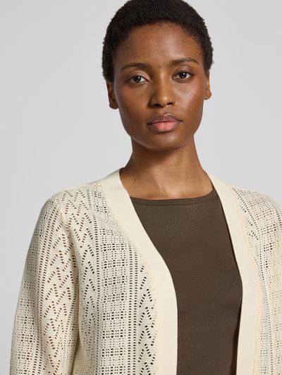 Modelka kobieca nosi Relaxed Fit Bolero aus Baumwoll-Mix od s.Oliver RED LABEL w kremowych i brązowych odcieniach, tekstura ażurowa, zbliżenie na górną część ciała