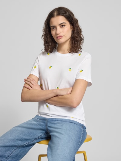 Kobiece modelka nosi damski t-shirt w kolorze białym z aplikacjami haftów cytryn, krój regular fit, okrągły dekolt, krótki rękaw, wykonany z czystej bawełny ekologicznej, Regular Fit T-Shirt aus reiner Bio-Baumwolle Modell 'KETTY LIFE' od ONLY, efekt: jednolity kolor, aplikacja: hafty, damski t-shirt, widok: ujęcie całej sylwetki z przodu.
