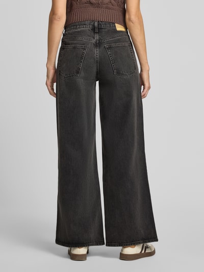 Vrouwenmodel draagt Wide & Loose Fit Jeans uit puur katoen, model 'ASTRAEAAS' van ARMEDANGELS, donkere denim, dames jeans, geheel lichaamsaanzicht achteraan.
