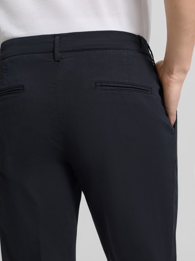 Männermodel trägt Relaxed Fit Hose mit Bügelfalten von Profuomo aus Baumwoll-Elasthan-Mix, Gesäßtaschen, Nahaufnahme Rückansicht.