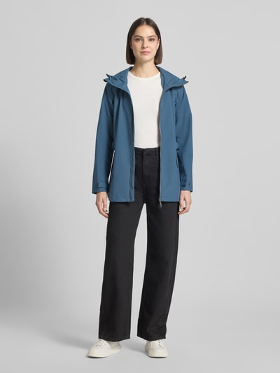 Frauenmodel trägt Regular Fit Regenmantel mit Logo-Detail von G.I.G.A. DX in Blau, Zweiwege-Reißverschluss, Eingrifftaschen, Ganzkörperansicht von vorne, Rückenlänge 76 cm, Schulterbreite 40 cm, Brustweite 50 cm, Ärmellänge 66 cm.