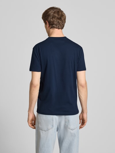 Männermodel trägt Regular Fit T-Shirt aus reiner Baumwolle von Tommy Jeans in Dunkelblau, unifarben, kurzarm, Rundhals, Jersey, Ganzkörperansicht Rückansicht.