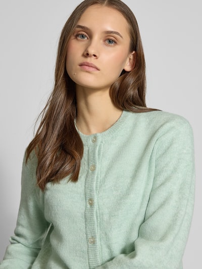 Frauenmodel trägt Regular Fit Strickjacke mit einreihiger Knopfleiste Modell 'SIMONI' von ONLY, Optik: Unifarben, Nahaufnahme Oberkörper.