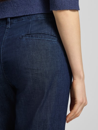 Frauenmodel trägt Wide Leg Jeans in verkürzter Passform Modell 'Maine' von Brax, dunkelblauer Baumwoll-Mix, Nahaufnahme Rückansicht.